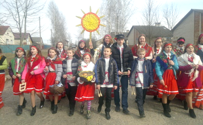 Дзяўчаты нясуць птушынае гняздо з печывам для птушак, каб пакінуць яго на дрэве.